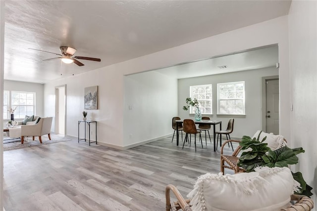 living room with ceiling fan and light hardwood / wood-style floors