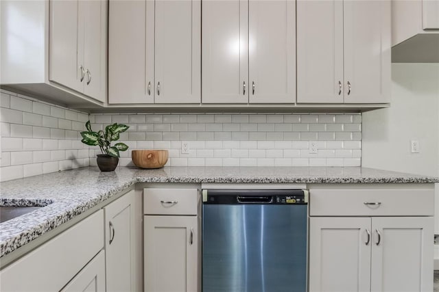 kitchen with tasteful backsplash, light stone countertops, dishwasher, and white cabinets