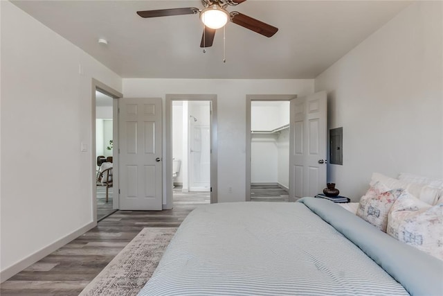 bedroom featuring ensuite bathroom, ceiling fan, wood-type flooring, a spacious closet, and a closet