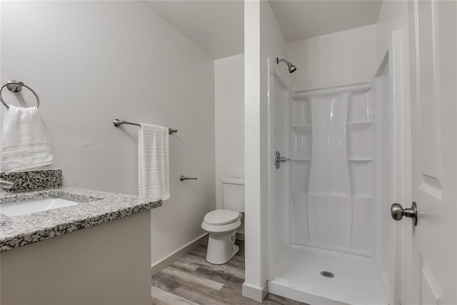 bathroom with a shower, toilet, vanity, and hardwood / wood-style flooring