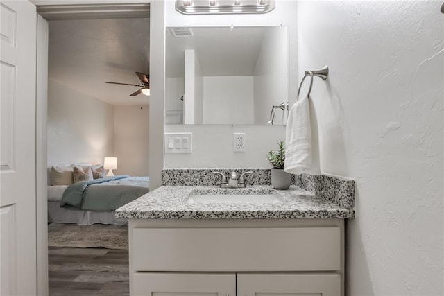 bathroom featuring ceiling fan, vanity, and wood-type flooring