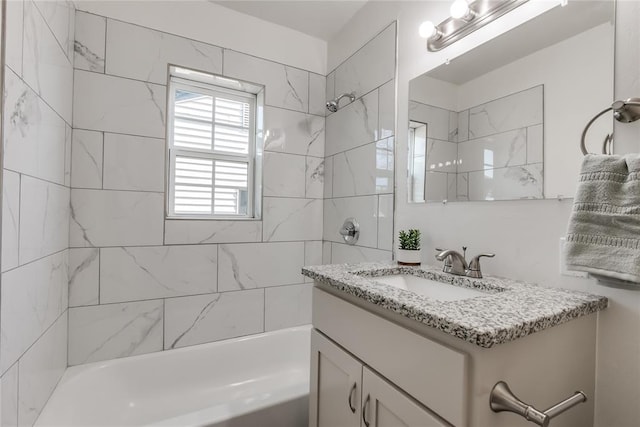 bathroom featuring vanity and tiled shower / bath