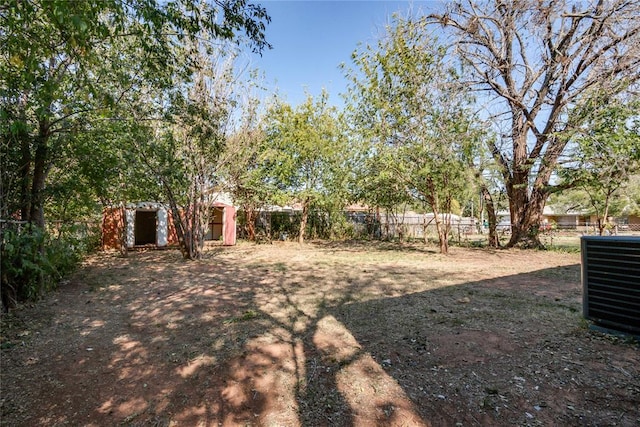 view of yard with central AC unit and a storage unit