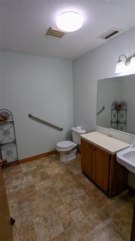 bathroom featuring a textured ceiling and toilet