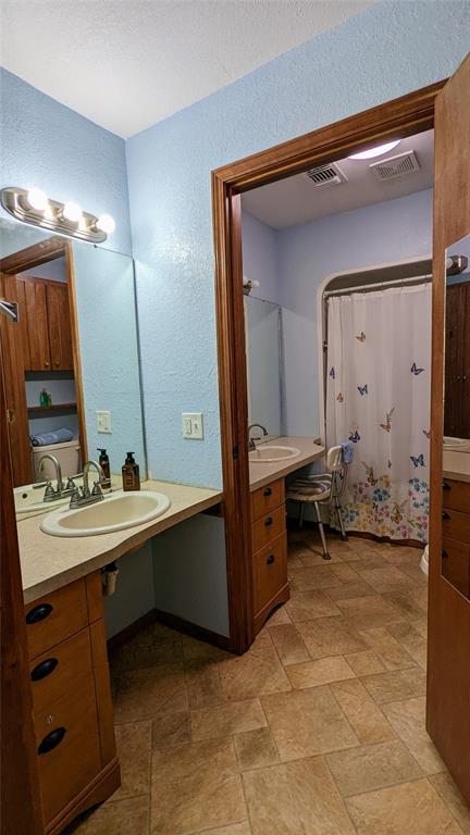 bathroom featuring a shower with shower curtain and sink