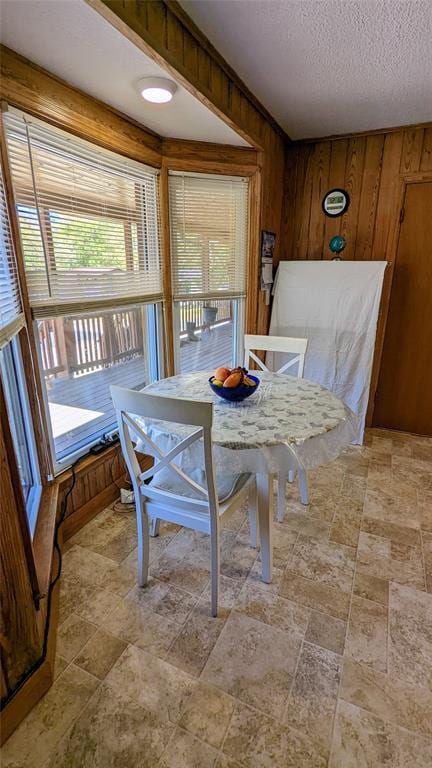 dining area with wood walls and a textured ceiling