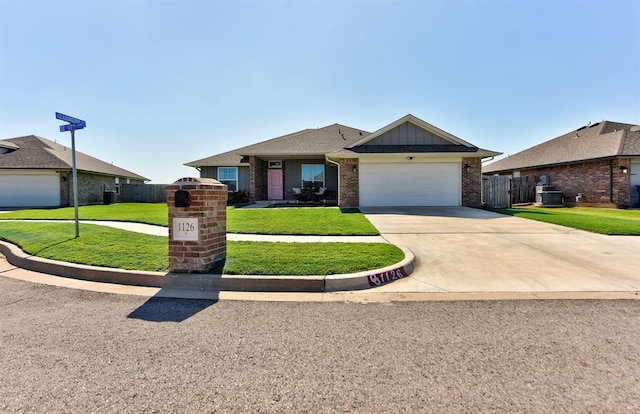 ranch-style home featuring a front yard, central AC, and a garage