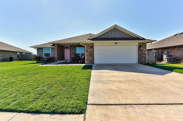 single story home with central air condition unit, a front lawn, and a garage