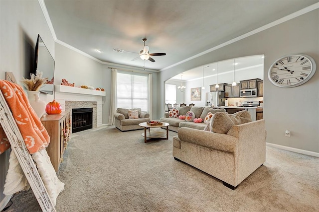 carpeted living room with ceiling fan and crown molding