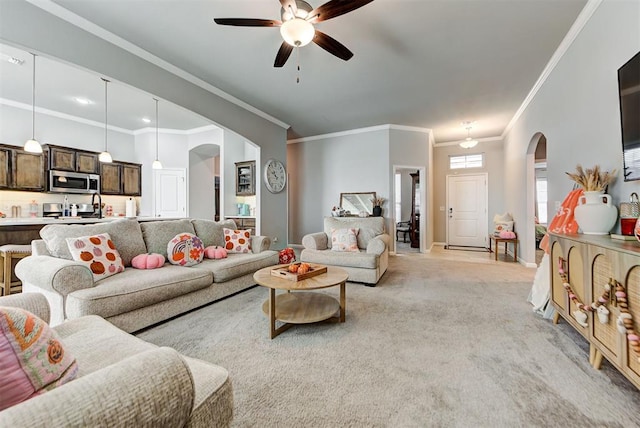 carpeted living room featuring ceiling fan and crown molding