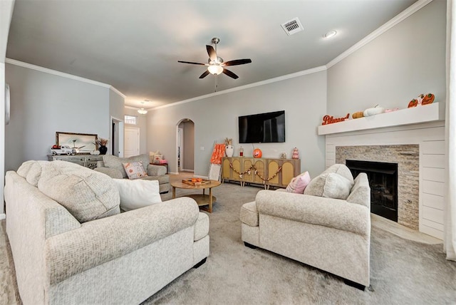 carpeted living room with a fireplace, ceiling fan, and crown molding