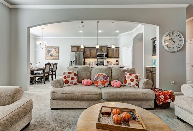 living room with ornamental molding, light colored carpet, and a notable chandelier