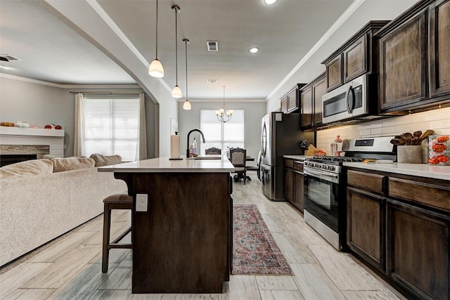 kitchen with a wealth of natural light, sink, an island with sink, and appliances with stainless steel finishes