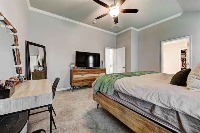 carpeted bedroom with lofted ceiling, a walk in closet, ceiling fan, and ornamental molding