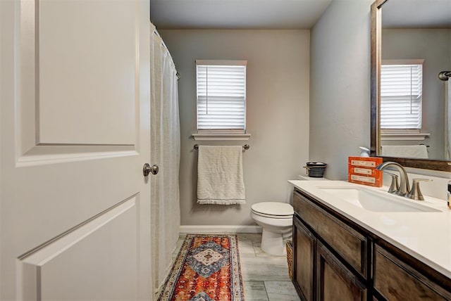 bathroom featuring vanity, toilet, and a wealth of natural light