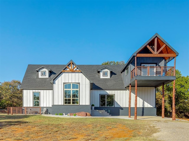 view of front of property featuring a balcony and a front yard