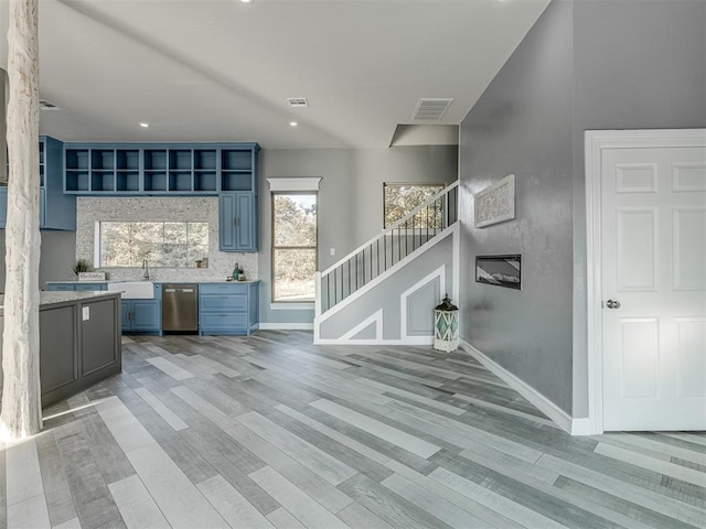 unfurnished living room with light wood-type flooring and sink