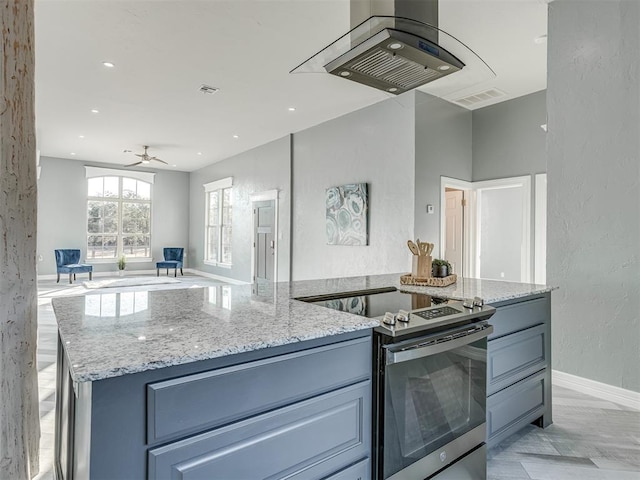 kitchen with light stone countertops, electric range, island range hood, and ceiling fan