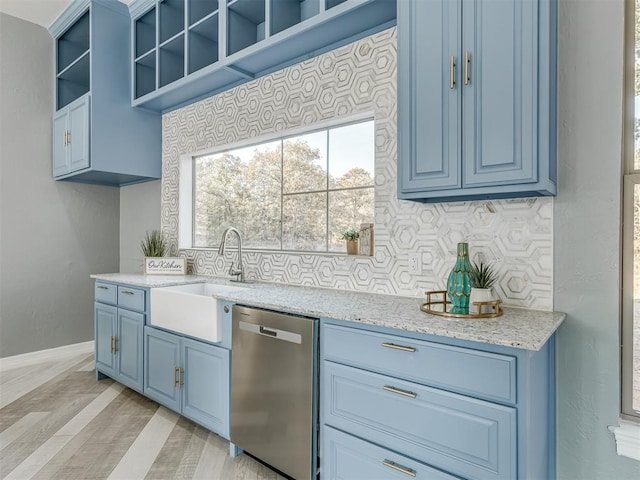 kitchen featuring dishwasher, sink, light stone countertops, light wood-type flooring, and tasteful backsplash