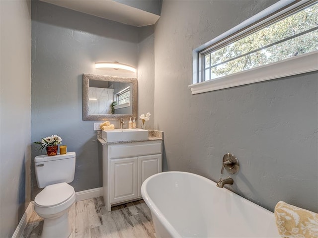 bathroom featuring hardwood / wood-style floors, a bathtub, toilet, and vanity