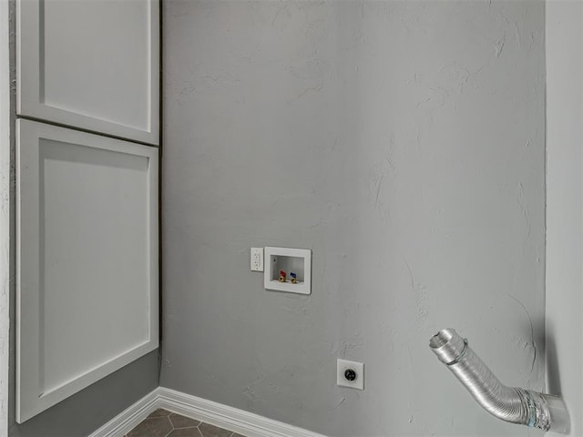 laundry room with cabinets, hookup for a washing machine, dark tile patterned flooring, and electric dryer hookup