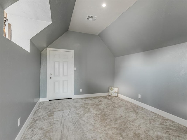 additional living space with light carpet and vaulted ceiling