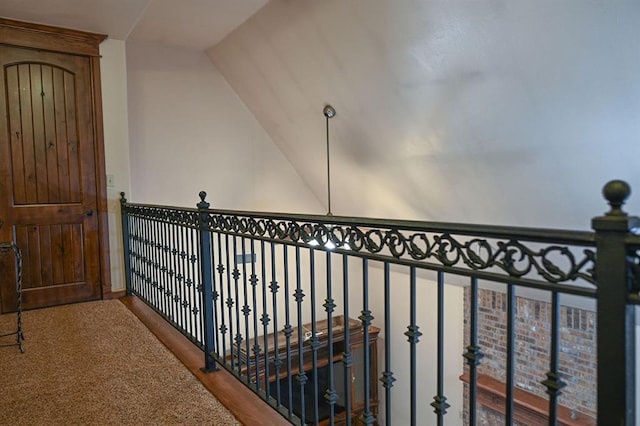 hallway featuring carpet floors and vaulted ceiling