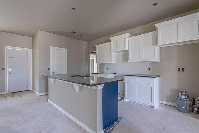 kitchen featuring a center island, a kitchen bar, and white cabinetry