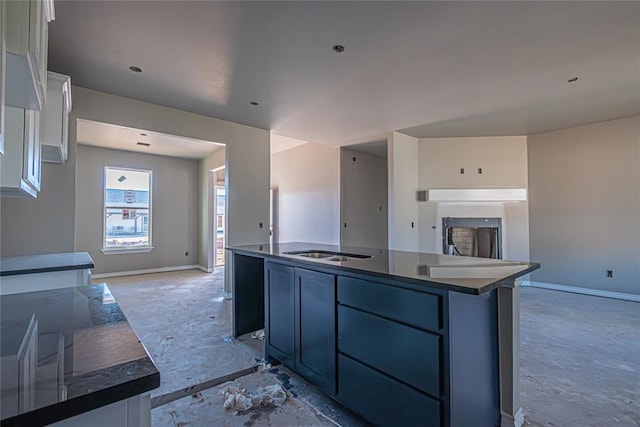 kitchen featuring white cabinets, sink, and a kitchen island with sink