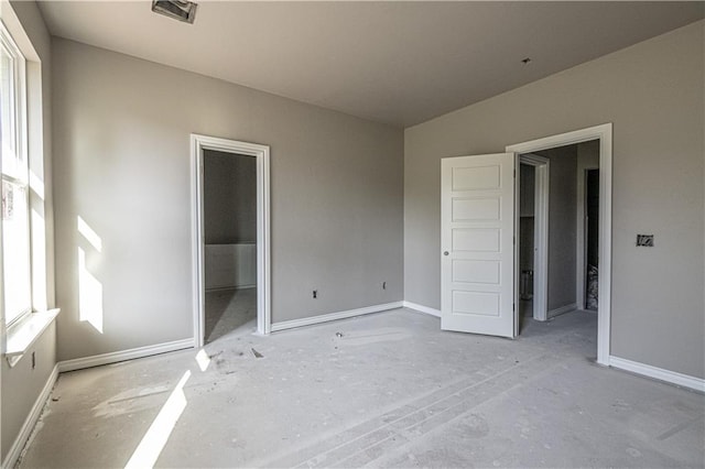 unfurnished bedroom with a walk in closet