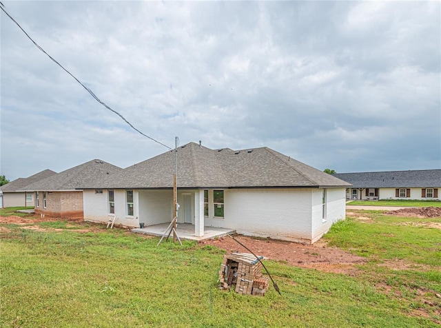 back of property featuring a lawn and a patio area