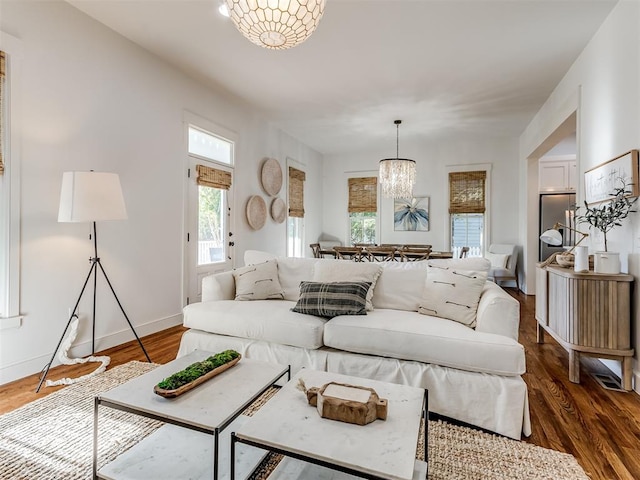 living room with dark hardwood / wood-style flooring and a chandelier