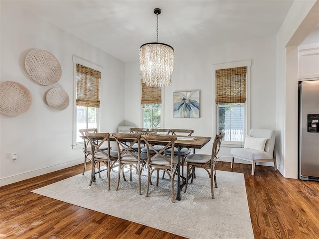 dining room featuring dark hardwood / wood-style floors, a healthy amount of sunlight, and an inviting chandelier