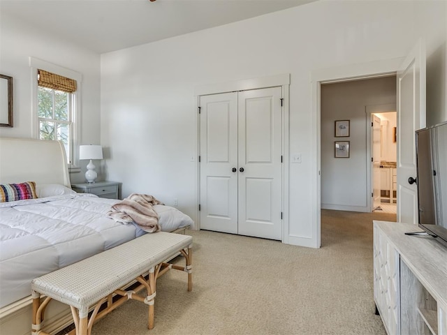 bedroom featuring light carpet and a closet