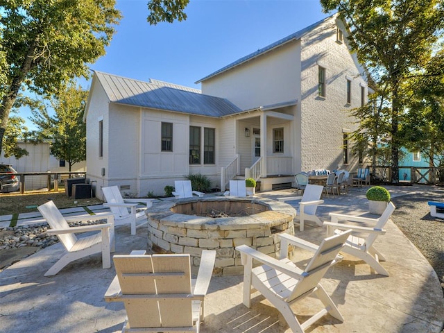 back of property with a patio and a fire pit