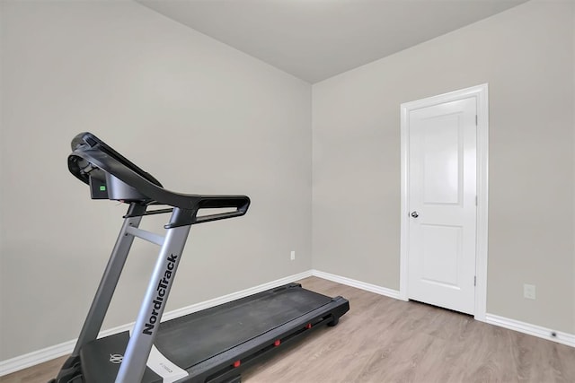 exercise room with light wood finished floors and baseboards