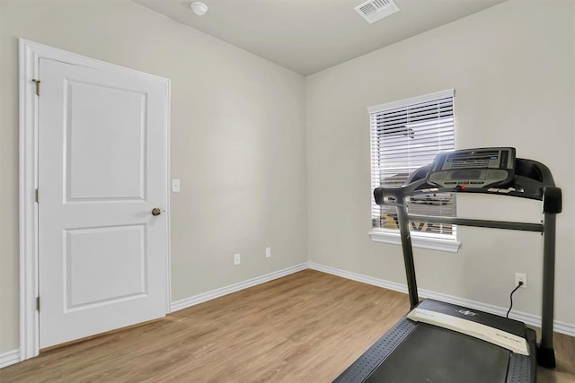 exercise room featuring light wood-style flooring, visible vents, and baseboards