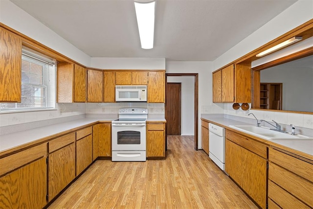 kitchen featuring backsplash, sink, white appliances, and light hardwood / wood-style flooring