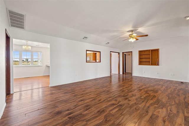 empty room featuring ceiling fan with notable chandelier and dark wood-type flooring