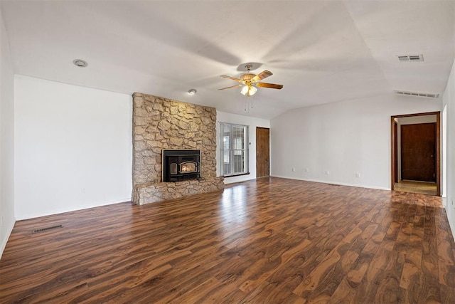 unfurnished living room with a wood stove, vaulted ceiling, ceiling fan, and dark wood-type flooring