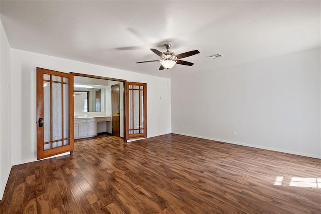 unfurnished living room with ceiling fan, french doors, and dark wood-type flooring