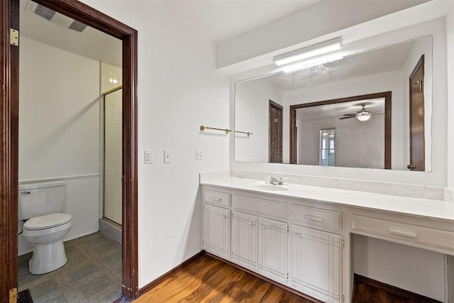 bathroom featuring vanity, ceiling fan, hardwood / wood-style flooring, toilet, and a shower with shower door