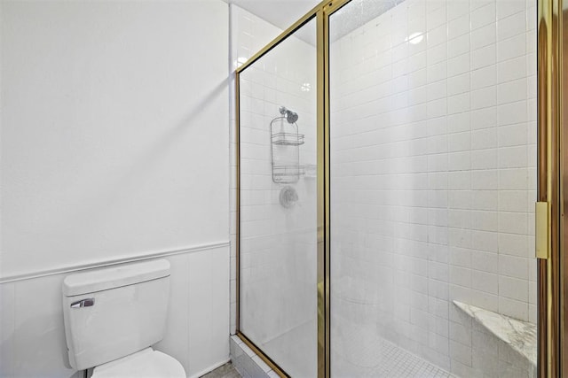 bathroom with toilet and a shower with shower door