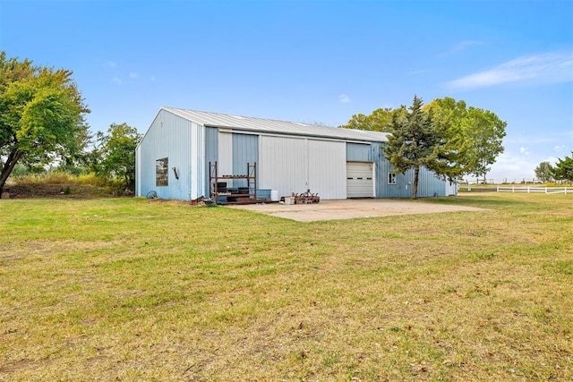 rear view of property featuring a lawn and an outdoor structure