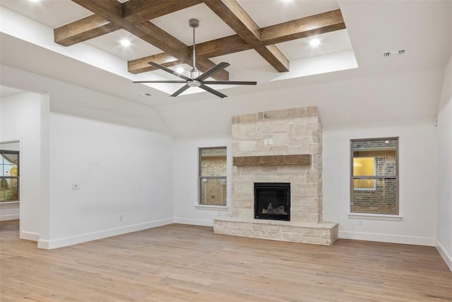 unfurnished living room featuring coffered ceiling, a fireplace, light hardwood / wood-style floors, and ceiling fan