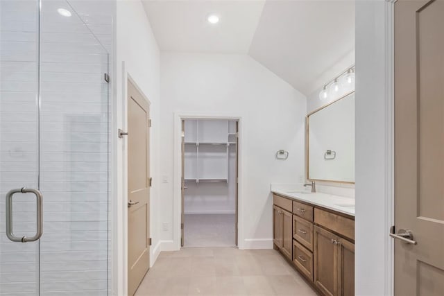 bathroom with walk in shower, vanity, and vaulted ceiling