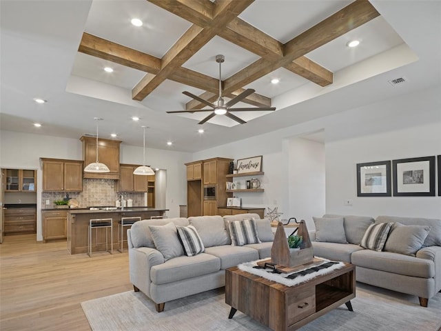 living room featuring beamed ceiling, coffered ceiling, and light hardwood / wood-style floors