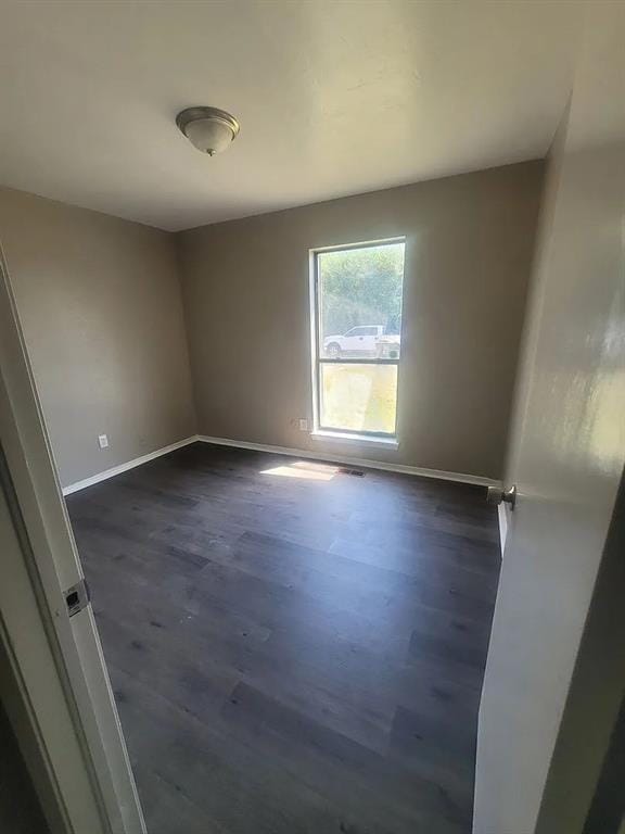 spare room featuring dark wood-type flooring