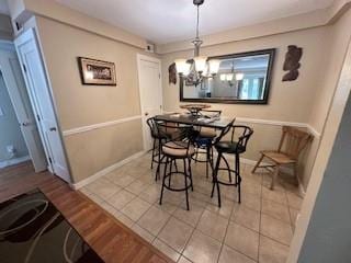 dining area with a notable chandelier and light tile patterned flooring