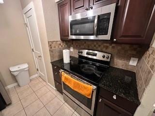 kitchen with decorative backsplash, dark brown cabinets, stainless steel appliances, and light tile patterned flooring